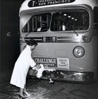 Mrs. Robert K. Barber wife of AC Transit board president breaks bottle of champagne over the bumper of bus 2103 to inaugurate AC Transit service on October 1, 1960.