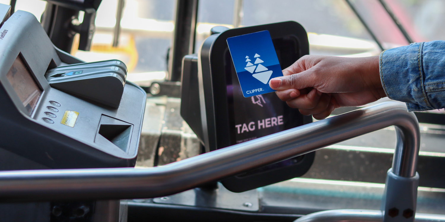 Clipper card being held up to Clipper Reader on AC Transit Bus