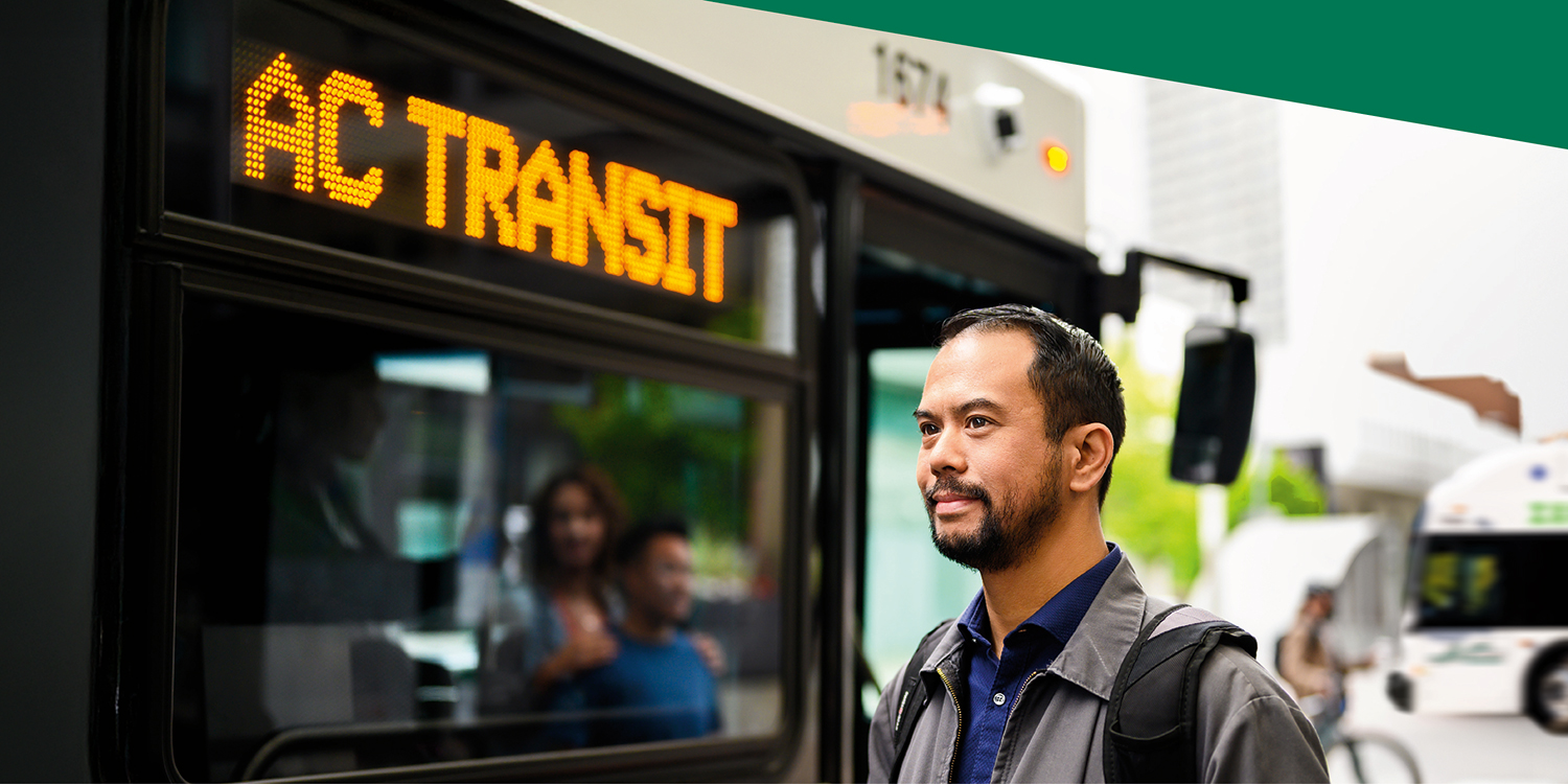 Man standing in front of AC Transit bus