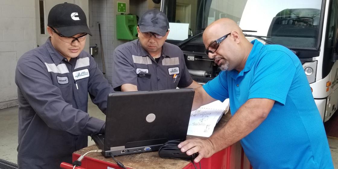 AC Transit mechanics looking at a laptop