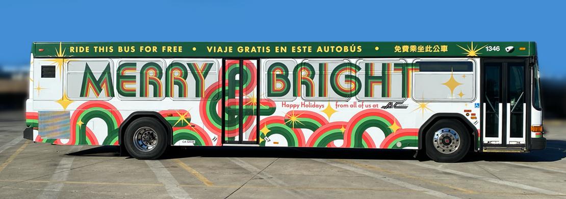 Holiday Bus parked in bus yard. Wrapping reads "Merry & Bright"