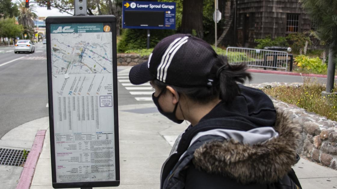 Woman looking at AC Transit schedule