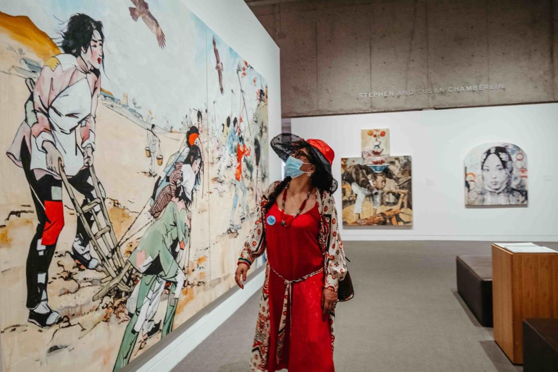 A visitor viewing artwork at Oakland Museum