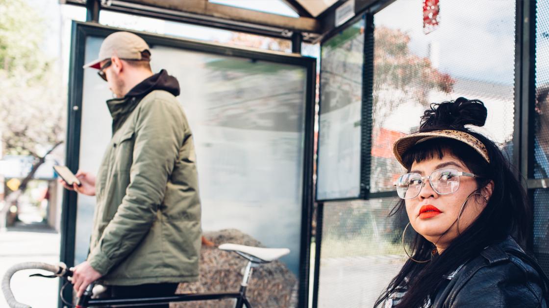Man and woman at AC Transit Bus Stop