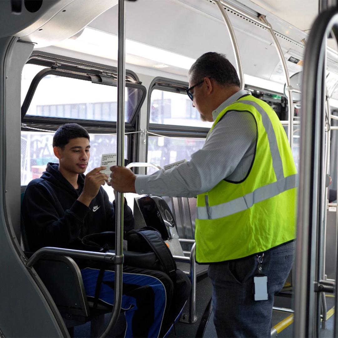 AC Transit General Manager Sal Llamas speaking with passenger on bus