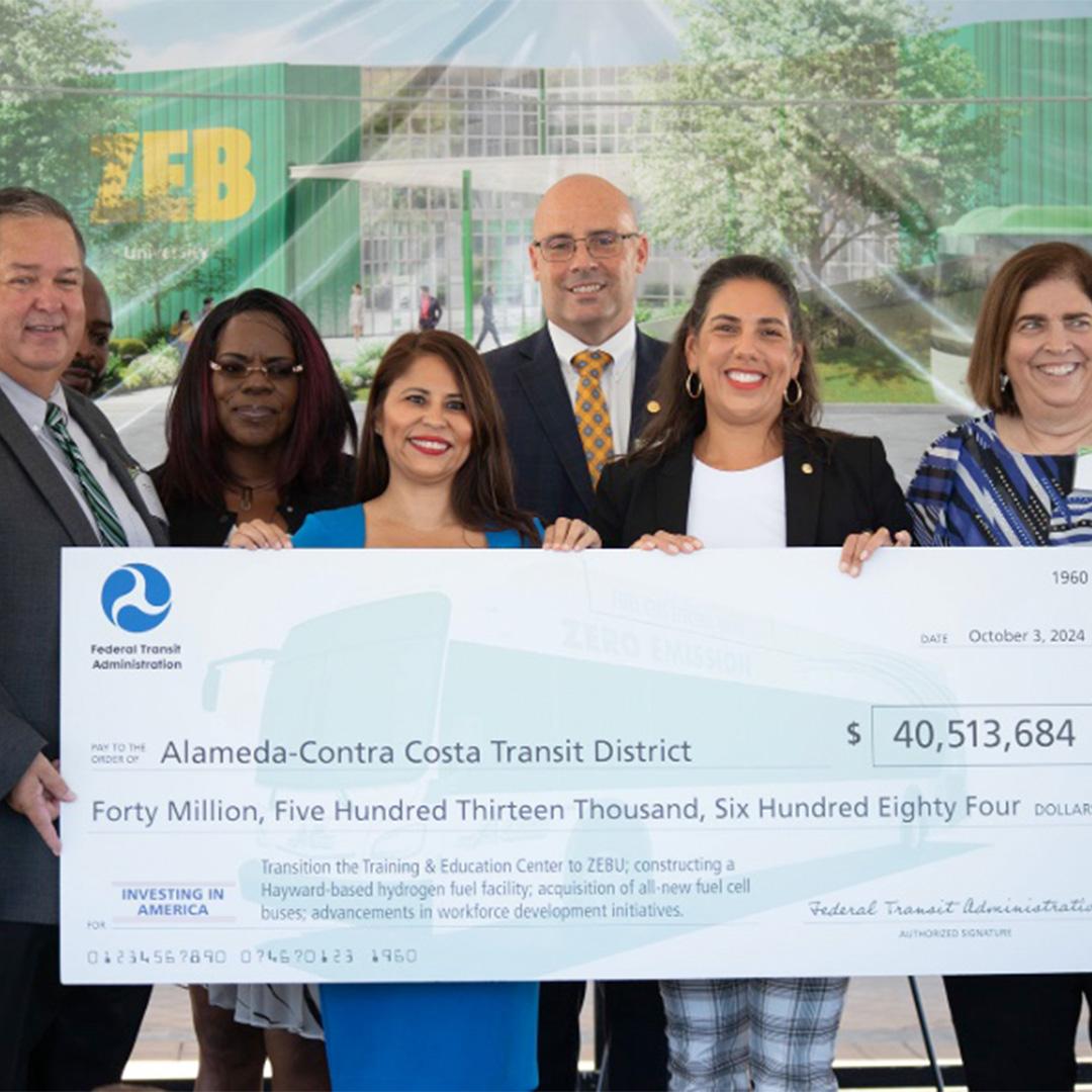 AC Transit executives, board directors, and local officials holding check for ZEBU grant from FTE