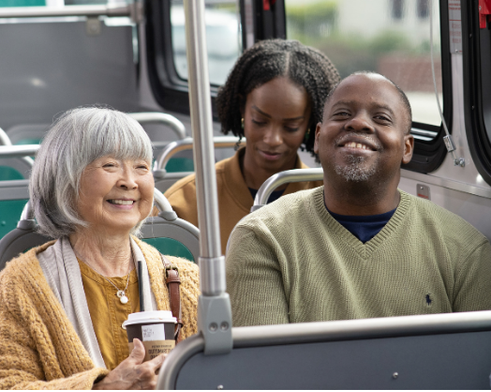 2 people sitting in seats on the bus